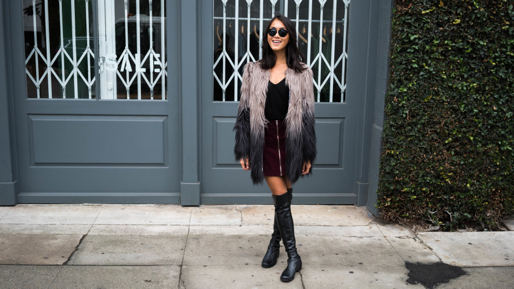 woman wearing Ombre fur coat, skirt, boots, and black top