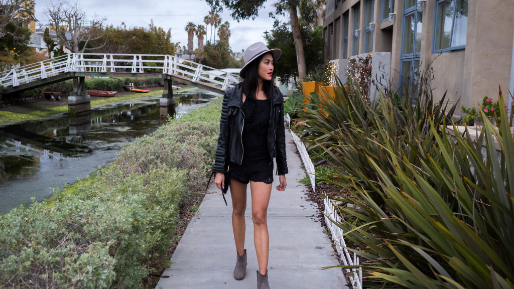 woman wearing black romper and walking near the river