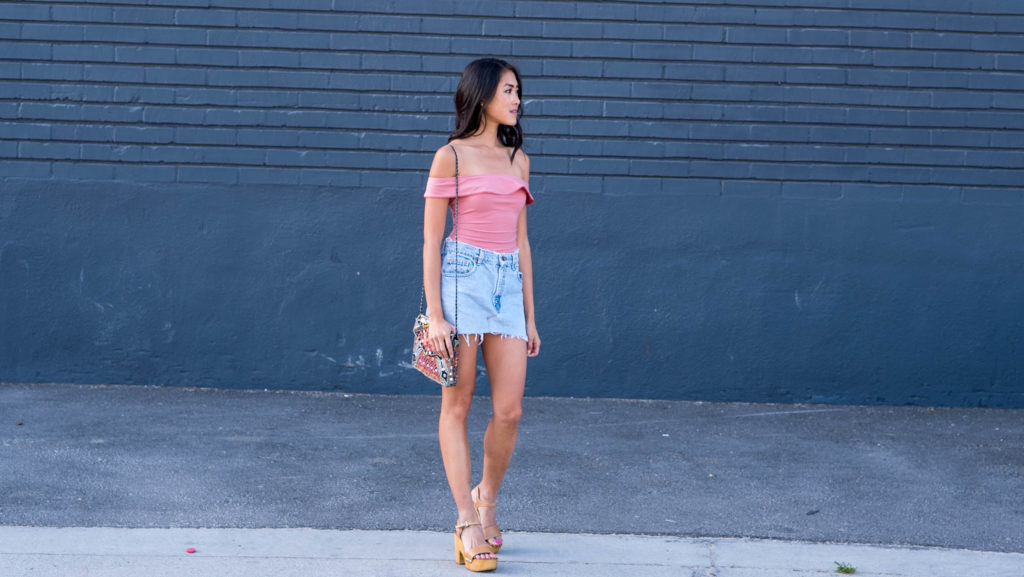 woman wearing Reformation Classon Bodysuit, Urban Outfitters Denim Skirt and sharing What Goes Around