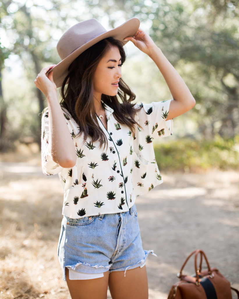 woman wearing denim shorts and printed top sharing Wanderlust