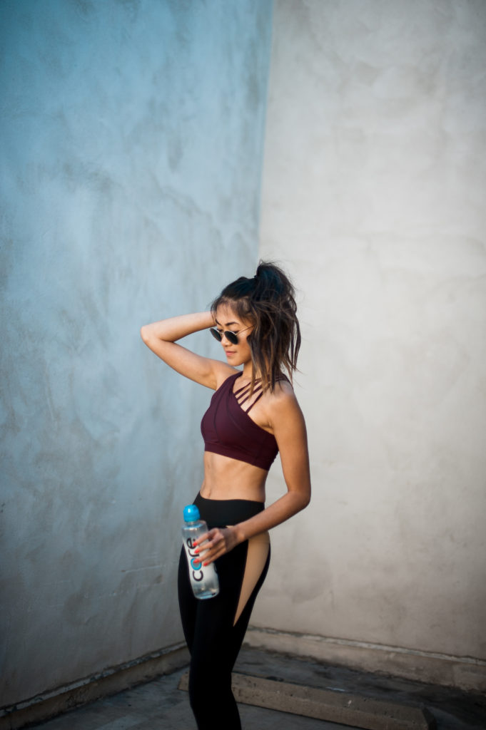 Gym Motivation woman wearing gym clothes and holding a water bottle