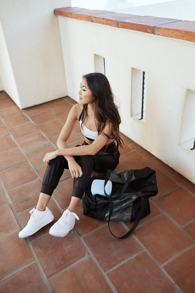 woman sitting on the floor with her gym bag