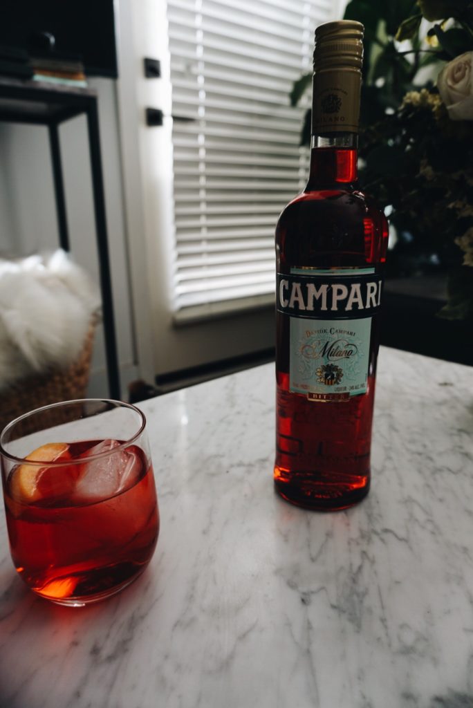 a glass of cocktail and a bottle of campari