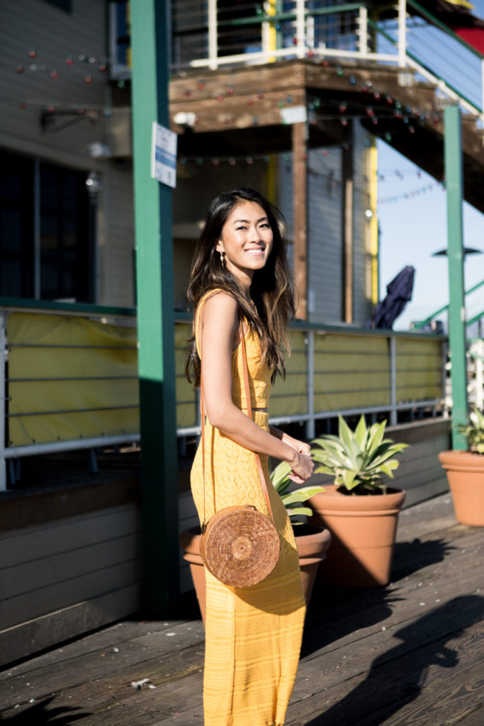 woman smiling wearing yellow top and skirt