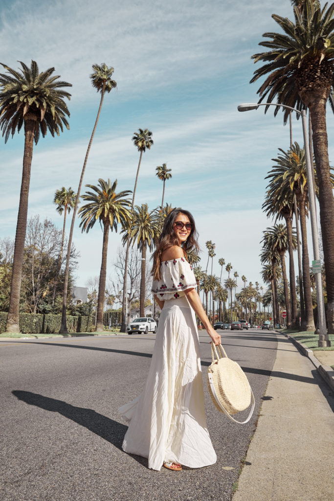 woman wearing white dress and holding white bag for Festival Season 