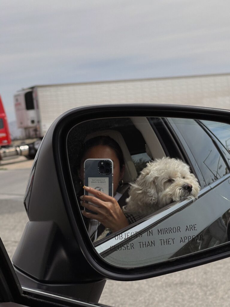 woman taking a selfie on his side mirror 